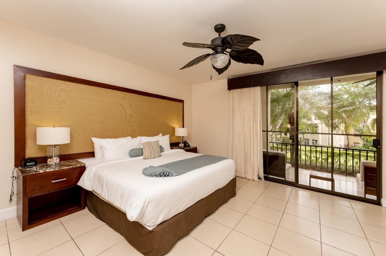 Master bedroom with balcony access and garden views